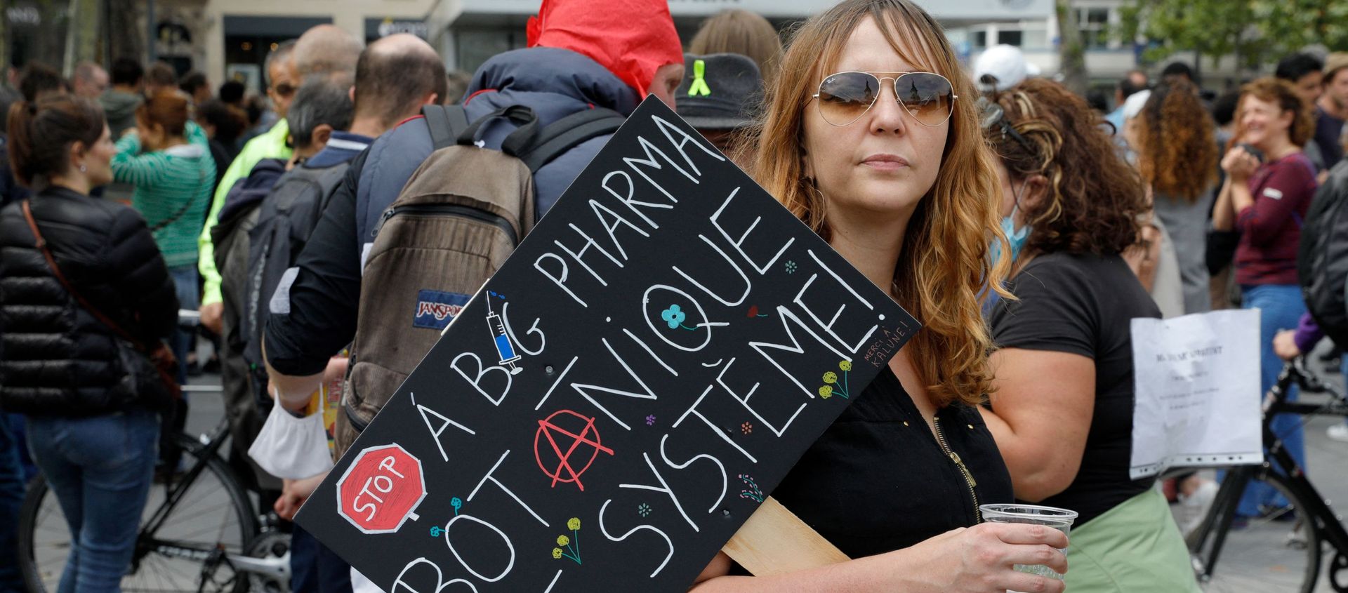 A woman holds a placard hostile to Pharmaceutical firms as she takes part in a gathering at Republic square in Paris on July 14, 2021 to protest against a governmental decision to impose Covid-19 tests for unvaccinated people who want to eat in restaurants or take long-distance trips, as the country looks to avoid a surge in more contagious Delta cases. A woman holds a placard hostile to Pharmaceutical firms as she takes part in a gathering at Republic square in Paris on July 14, 2021 to protest against a governmental decision to impose Covid-19 tests for unvaccinated people who want to eat in restaurants or take long-distance trips, as the country looks to avoid a surge in more contagious Delta cases. - Sputnik International, 1920, 17.07.2021