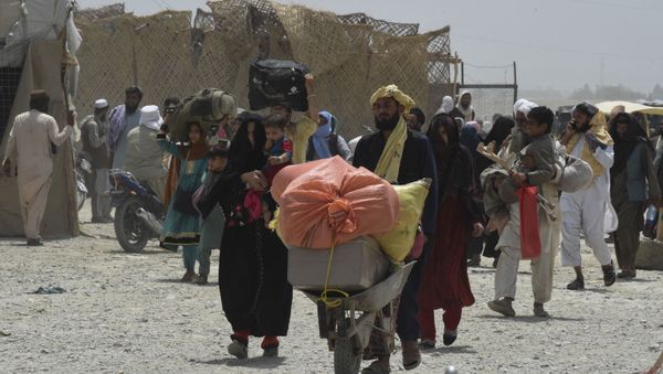 People walk towards a border crossing point in Pakistan's border town of Chaman on July 17, 2021, after Pakistan partially reopened its southern crossing with Afghanistan, shut off since the Taliban seized control of the strategic border town on the other side.  - Sputnik International
