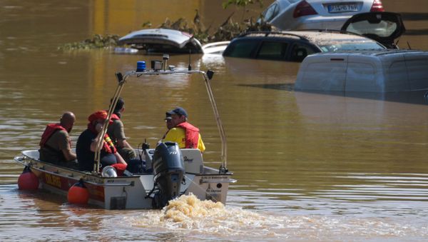 A rescue boat patrols next to submerged vehicles on the federal highway B265 in Erftstadt, western Germany, on July 17, 2021. - Sputnik International