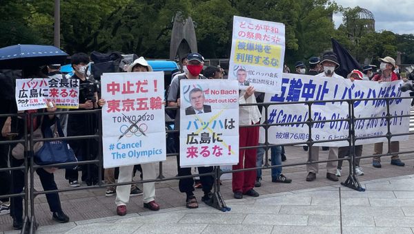 Protesters hold banners and placards including one (C) that reads Bach, Do not come to Hiroshima! ahead of the arrival of International Olympic Committee President Thomas Bach to the Hiroshima Memorial Cenotaph, in Hiroshima on July 16, 2021.  - Sputnik International