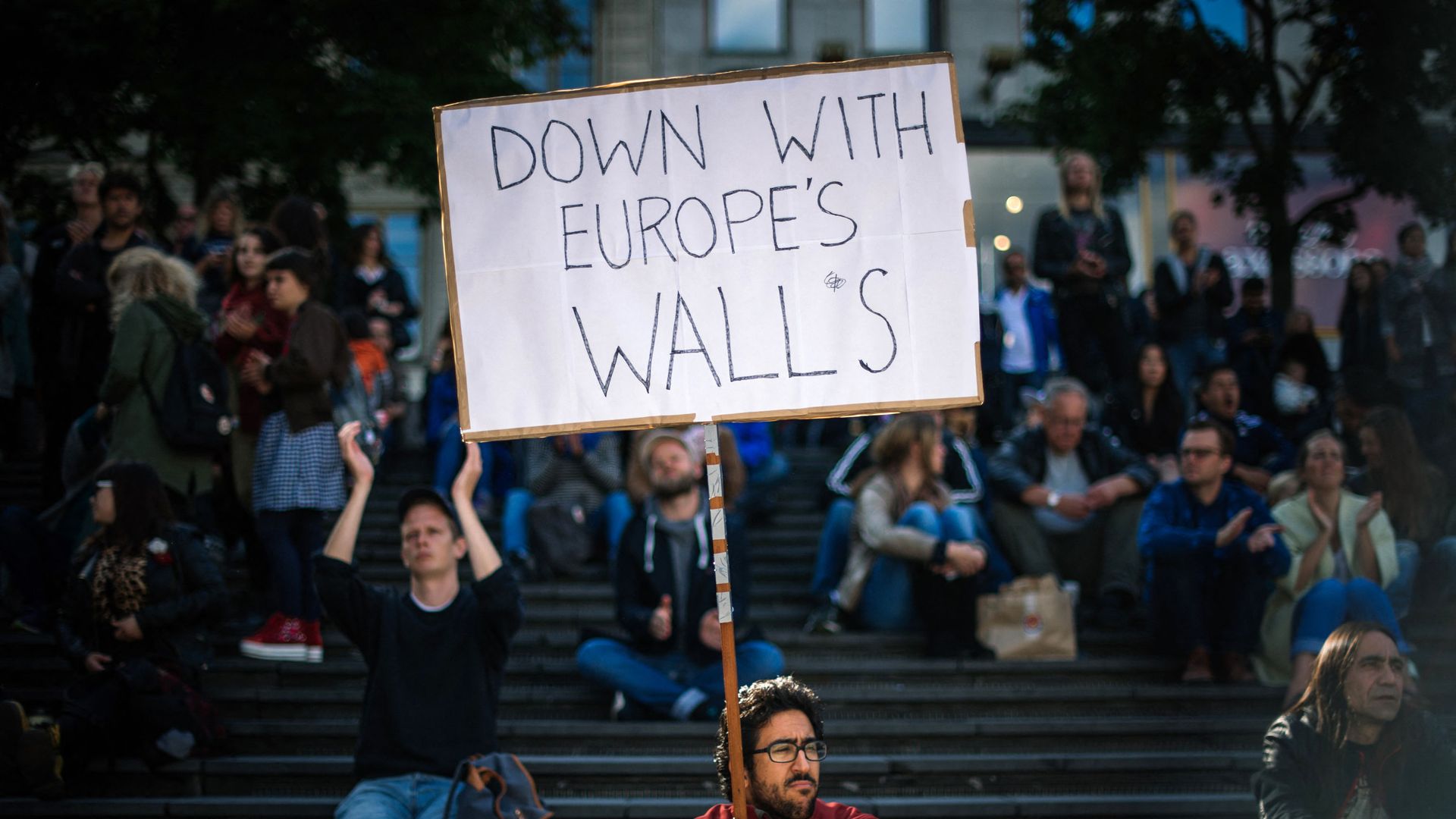 A man holds a sign as he takes part in a demonstration in solidarity with migrants seeking asylum in Europe after fleeing their home countries in Stockholm on September 12, 2015. A man holds a sign as he takes part in a demonstration in solidarity with migrants seeking asylum in Europe after fleeing their home countries in Stockholm on September 12, 2015. - Sputnik International, 1920, 20.07.2021