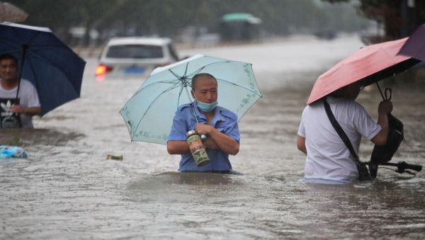 Residents wade through floodwaters on a flooded road amid heavy rainfall in Zhengzhou, Henan province, China July 20, 2021. Picture taken July 20, 2021.  - Sputnik International