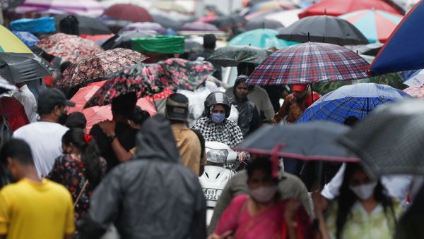 A woman rides a scooter through a crowded market on a rainy day amidst the spread of the coronavirus disease (COVID-19) in Mumbai, India, July 14, 2021.  - Sputnik International