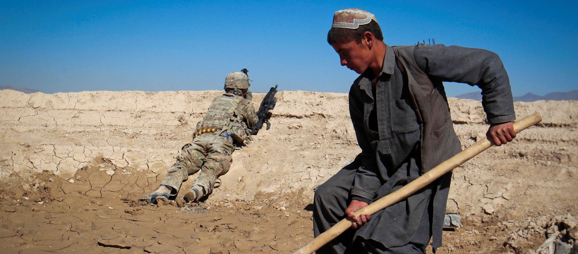 An Afghan boy works at a construction site as a U.S. Army soldier of 3/1 AD Task Force Bulldog takes position during a joint patrol with Afghan National Army (ANA) in a village in Kherwar district in Logar province, eastern Afghanistan, May 23, 2012. An Afghan boy works at a construction site as a U.S. Army soldier of 3/1 AD Task Force Bulldog takes position during a joint patrol with Afghan National Army (ANA) in a village in Kherwar district in Logar province, eastern Afghanistan, May 23, 2012. - Sputnik International, 1920, 31.08.2021