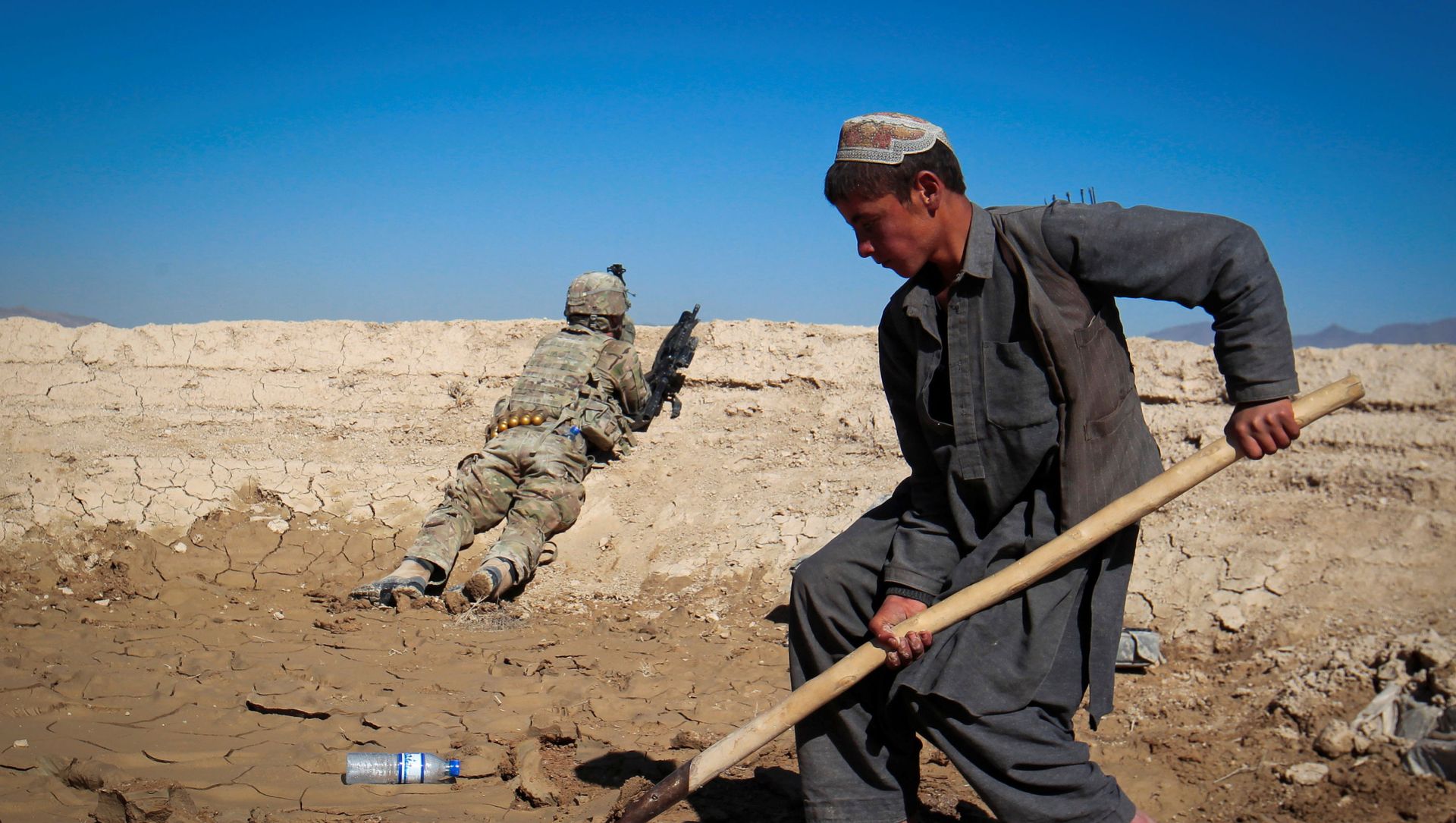 An Afghan boy works at a construction site as a U.S. Army soldier of 3/1 AD Task Force Bulldog takes position during a joint patrol with Afghan National Army (ANA) in a village in Kherwar district in Logar province, eastern Afghanistan, May 23, 2012. An Afghan boy works at a construction site as a U.S. Army soldier of 3/1 AD Task Force Bulldog takes position during a joint patrol with Afghan National Army (ANA) in a village in Kherwar district in Logar province, eastern Afghanistan, May 23, 2012. - Sputnik International, 1920, 31.08.2021