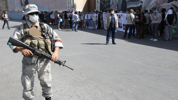 A police officer stands guard, while former Afghan interpreters, who worked with U.S. troops in Afghanistan demonstrate in front of the U.S. embassy in Kabul June 25, 2021.  - Sputnik International
