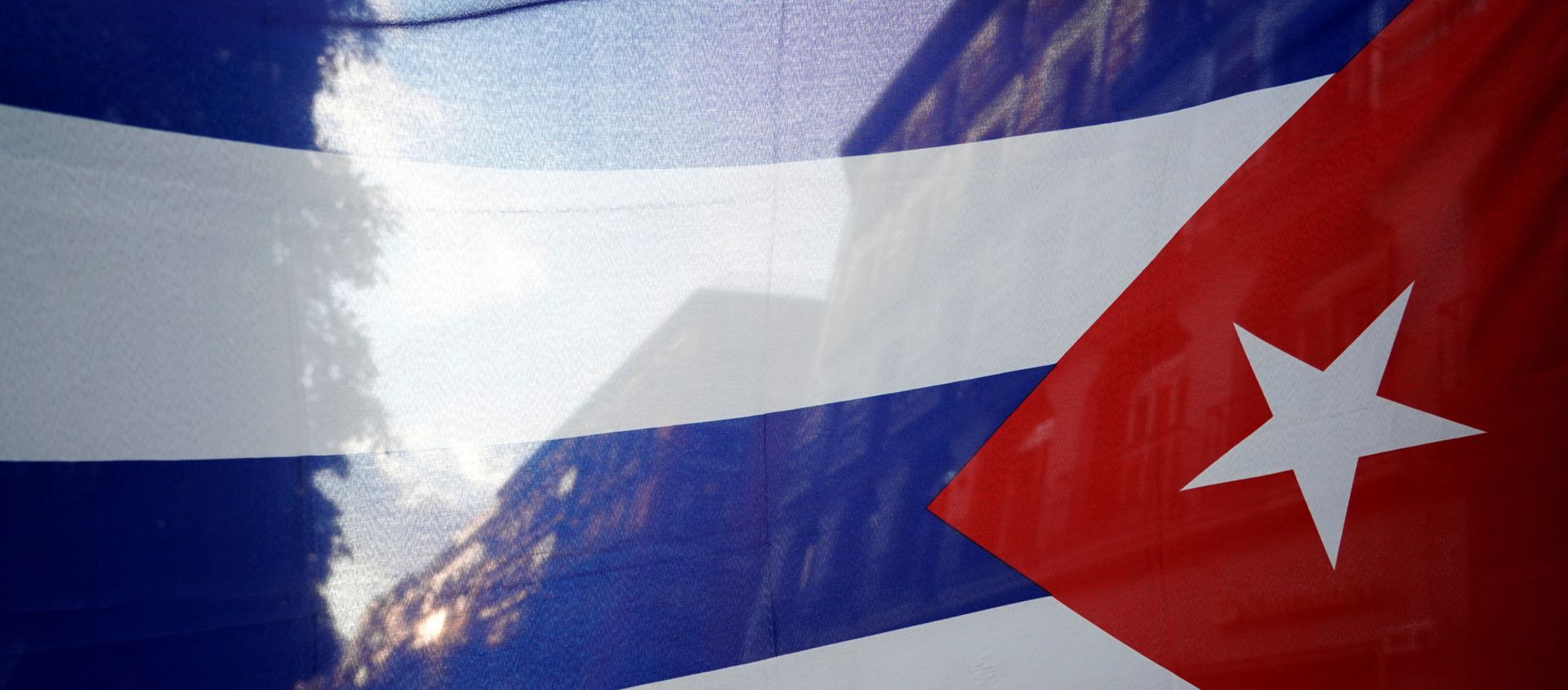 The silhouette of the city is seen through a Cuban flag during a protest against the  U.S. economic embargo in Cuba - Sputnik International, 1920