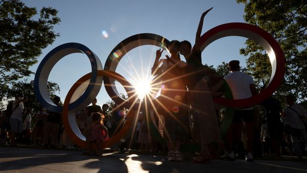 People pose for a photograph in front of an Olympic rings monument outside the National Stadium, the main stadium of Tokyo 2020 Olympic and Paralympic Games, amid the coronavirus disease (COVID-19) pandemic, in Tokyo, Japan July 31, 2021.  REUTERS/Issei Kato - Sputnik International