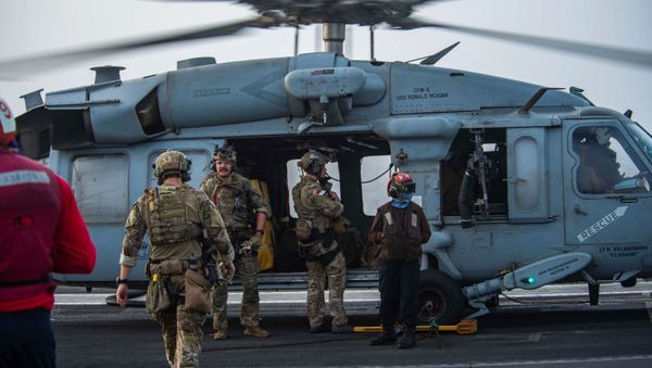 In this photo provided by the U.S. Navy, sailors assigned to an explosive ordnance unit board an MH-60S Seahawk helicopter on the flight deck of aircraft carrier USS Ronald Reagan to head to an oil tanker that was attacked off the coast of Oman in the Arabian Sea on Friday, July 30, 2021.  - Sputnik International