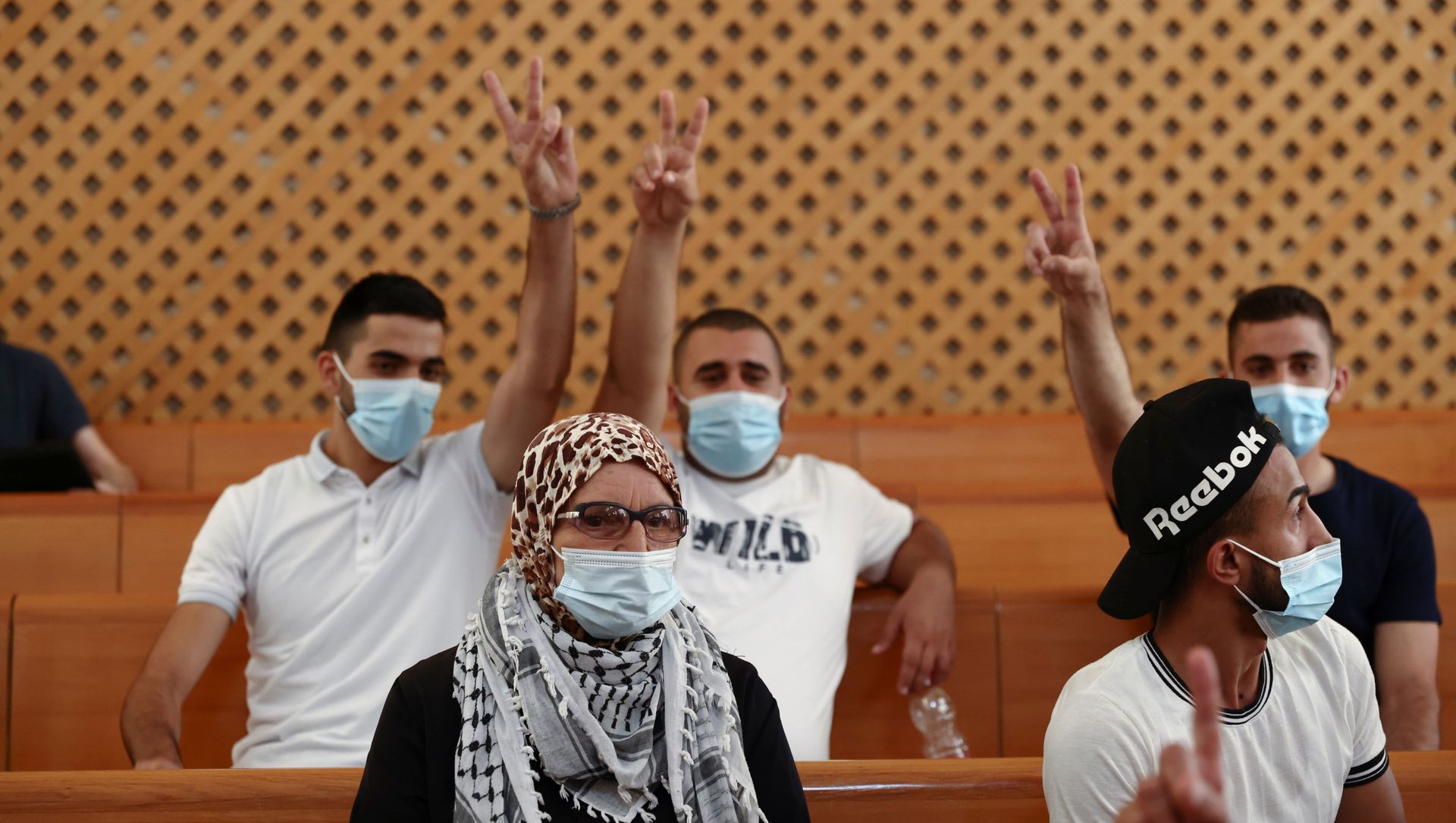 A supporter of the El-Kurd family, Palestinian residents of Sheikh Jarrah neighbourhood in East Jerusalem who are facing eviction, looks on as family members flash victory signs during a court hearing, in the Israeli Supreme Court, in Jerusalem August 2, 2021. A supporter of the El-Kurd family, Palestinian residents of Sheikh Jarrah neighbourhood in East Jerusalem who are facing eviction, looks on as family members flash victory signs during a court hearing, in the Israeli Supreme Court, in Jerusalem August 2, 2021. - Sputnik International, 1920, 03.08.2021