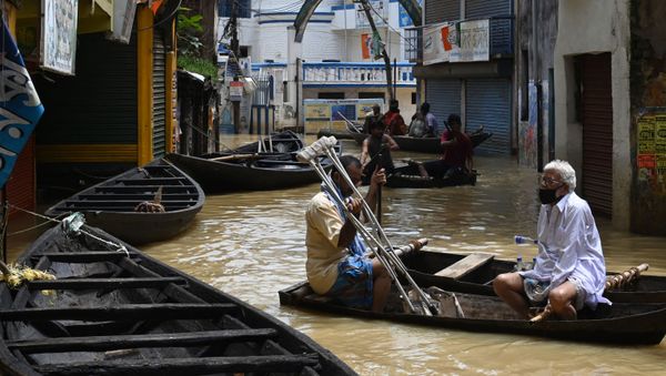 Residents ride a boat over a road submerged by floodwaters following heavy monsoon rains in Ghatal, Paschim Medinipur district, about 100 km from Kolkata on August 2, 2021.  - Sputnik International