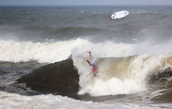 Gabriel Medina of Brazil in action as he falls into the sea with his surfboard seen above him. - Sputnik International