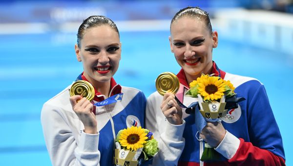 Russian artistic swimming duo, Svetlana Kolesnichenko and Svetlana Romashina (R), react after they won gold for their freestyle routine at the 2020 Tokyo Olympics, 4 August 2021 - Sputnik International
