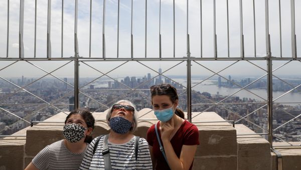 People in masks stand on the observation deck of the Empire State Building during the outbreak of the coronavirus disease (COVID-19) in New York City, U.S. - Sputnik International