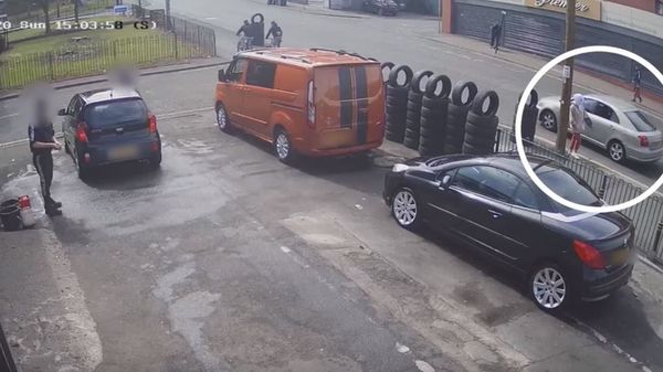 Aya Hachem (circled) walks past the Toyota Avensis just as hitman Zamir Raja prepares to fire at Quick Shine Tyres in Blackburn - Sputnik International