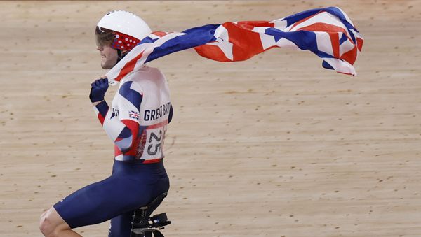 Britain's Matthew Walls celebrates with a flag after winning the men's track cycling omnium points race during the Tokyo 2020 Olympic Games at Izu Velodrome in Izu, Japan, on August 5, 2021. - Sputnik International