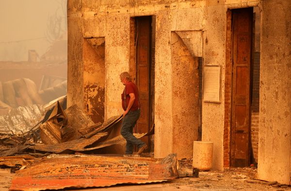 Resident Woody Hovland inspects a burned-out commercial building owned by his friend following the Dixie fire, a wildfire that tore through the town of Greenville, California on 5 August 2021. - Sputnik International