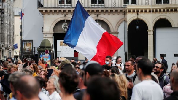 Protesters hold a French flag during a demonstration called by the yellow vests (gilets jaunes) movement against France's restrictions, including a compulsory health pass, to fight the coronavirus disease (COVID-19) outbreak in Paris, France, August 5, 2021. - Sputnik International