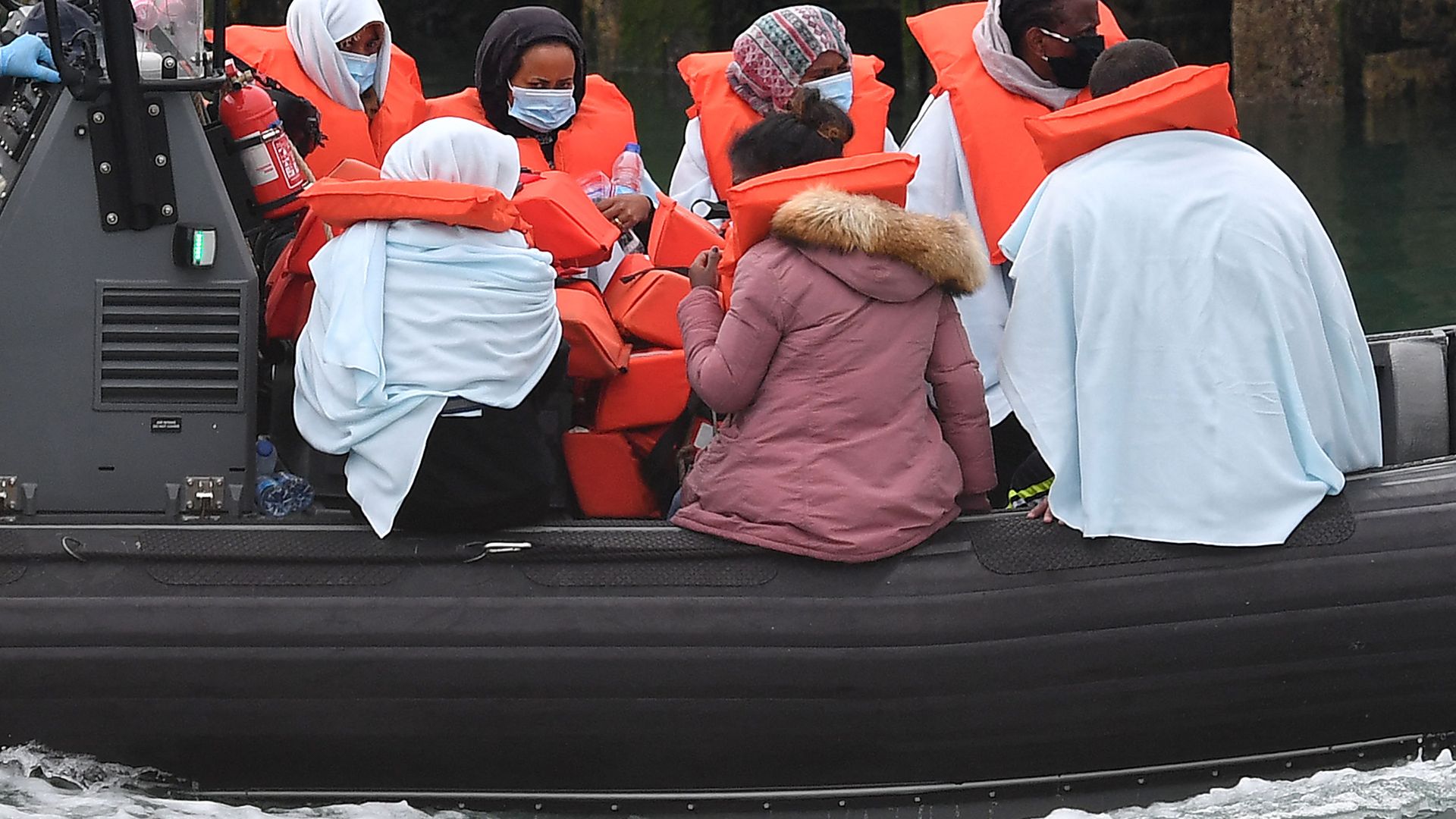 Migrants picked up at sea whilst Crossing the English Channel, but intercepted but intercepted bu UK Border Force officials, travel in a RIB with as they are brought into the Marina in Dover, southeast England on August 15, 2020. (Photo by Ben STANSALL / AFP) - Sputnik International, 1920, 04.11.2021