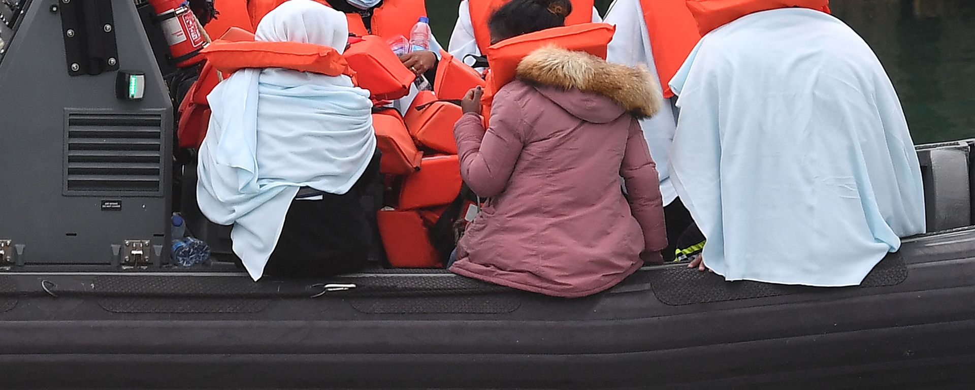 Migrants picked up at sea whilst Crossing the English Channel, but intercepted but intercepted bu UK Border Force officials, travel in a RIB with as they are brought into the Marina in Dover, southeast England on August 15, 2020. (Photo by Ben STANSALL / AFP) - Sputnik International, 1920, 18.11.2021