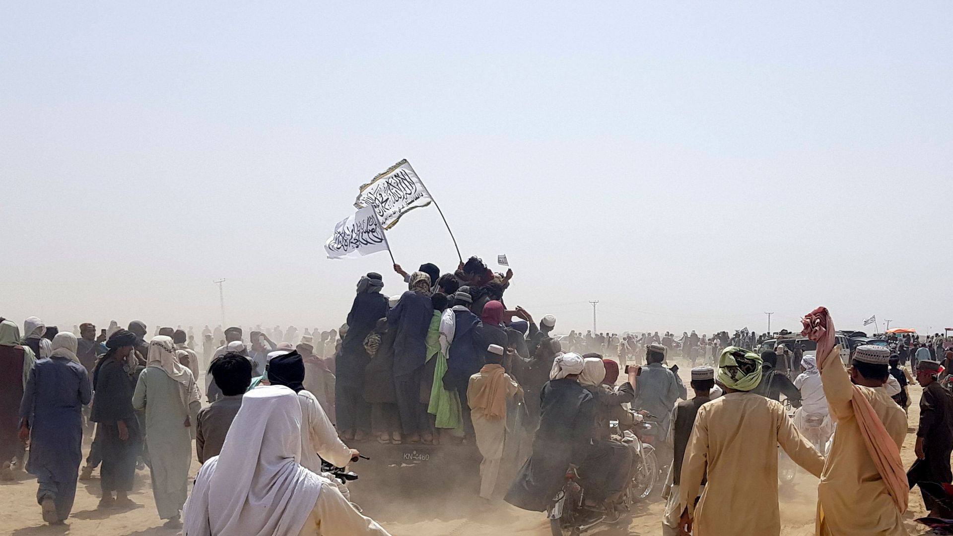 People standing on a vehicle hold Taliban flags as people gather near the Friendship Gate crossing point in the Pakistan-Afghanistan border town of Chaman, Pakistan, 14 July 2021.  - Sputnik International, 1920, 08.08.2021