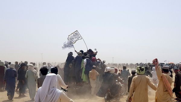 People standing on a vehicle hold Taliban flags as people gather near the Friendship Gate crossing point in the Pakistan-Afghanistan border town of Chaman, Pakistan, 14 July 2021.  - Sputnik International
