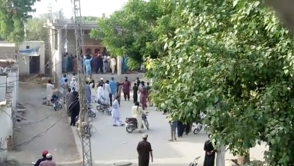 People gather outside a Hindu temple that was set on fire by an angry mob after reports that a Hindu boy had urinated in the library of an Islamic seminary, in Bhong, Pakistan August 4, 2021 in this screen grab from a social media video - Sputnik International