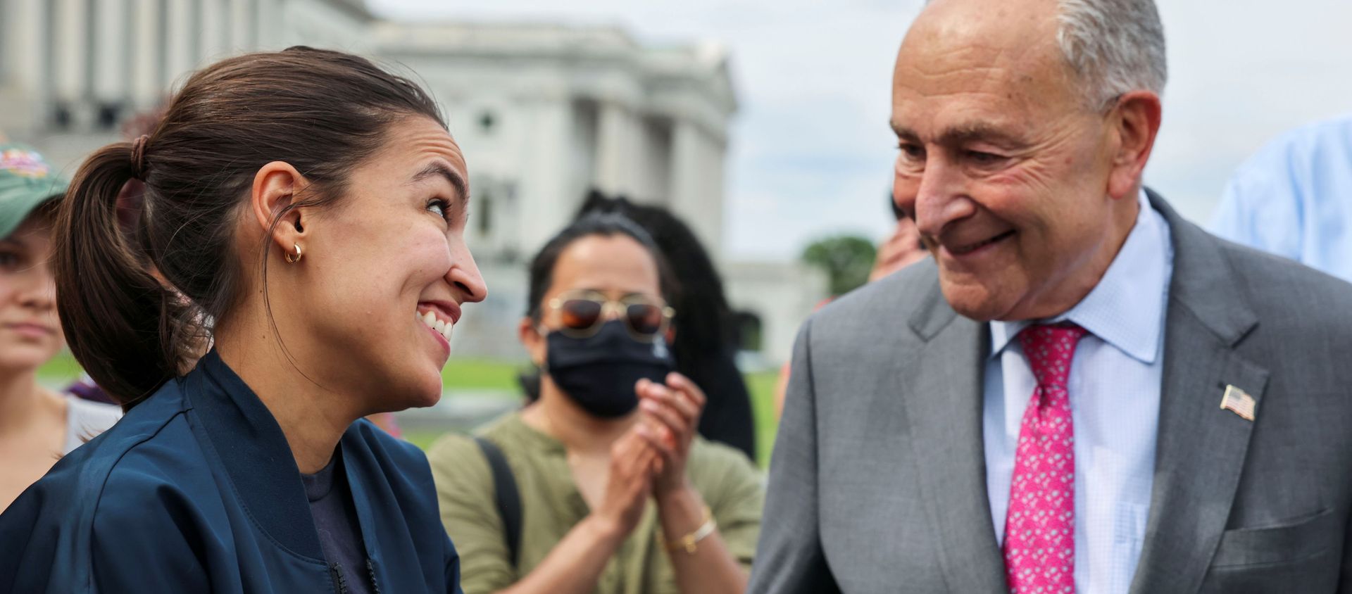 U.S. Representative Alexandria Ocasio-Cortez (D-NY) talks with U.S. Senate Majority Leader Chuck Schumer (D-NY) as they celebrate outside the U.S. Capitol Building after news that the White House intends to extend the eviction moratorium in place because of the coronavirus disease (COVID-19) pandemic, on Capitol Hill in Washington, U.S., August 3, 2021. - Sputnik International, 1920, 09.08.2021