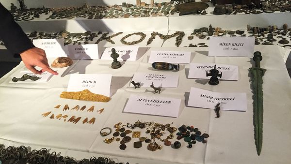 A Turkish police officer points to historical artifacts after police confiscated thousands of historical artifacts in a giant operation against smugglers in Istanbul, the private Dogan news agency reported on December 21, 2017 - Sputnik International