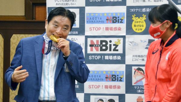 FILE PHOTO: Nagoya city Mayor Takashi Kawamura bites the Tokyo 2020 Olympic Games gold medal of the softball athlete Miu Goto during a ceremony in Nagoya, central Japan, 4 August 2021, in this photo taken by Kyodo.  - Sputnik International