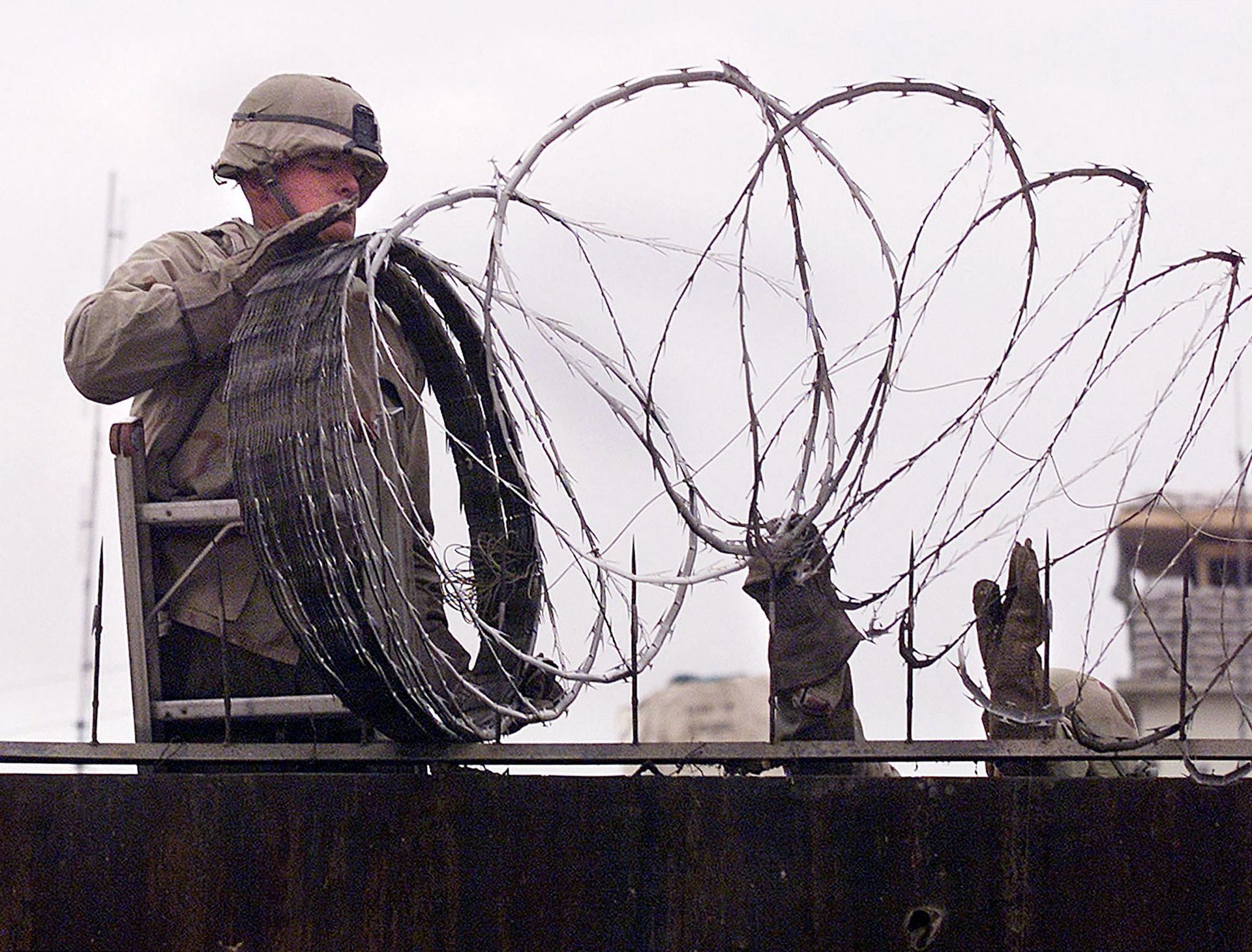 In this file photo a US Marine is given a hand using barbed wire to secure the walls the US embassy in Kabul on January 11, 2002. - The United States said on August 12, 2021 it was sending troops to the international airport in Afghanistan's capital Kabul to pull out US embassy staff as the Taliban makes rapid gains.We are further reducing our civilian footprint in Kabul in light of the evolving security situation, State Department spokesman Ned Price told reporters.This president prioritizes above all else the safety and security of Americans who are serving overseas, he said of Joe Biden, who has ordered a withdrawal of US troops from Afghanistan after nearly 20 years. In this file photo a US Marine is given a hand using barbed wire to secure the walls the US embassy in Kabul on January 11, 2002. - The United States said on August 12, 2021 it was sending troops to the international airport in Afghanistan's capital Kabul to pull out US embassy staff as the Taliban makes rapid gains.We are further reducing our civilian footprint in Kabul in light of the evolving security situation, State Department spokesman Ned Price told reporters.This president prioritizes above all else the safety and security of Americans who are serving overseas, he said of Joe Biden, who has ordered a withdrawal of US troops from Afghanistan after nearly 20 years. - Sputnik International, 1920, 07.09.2021