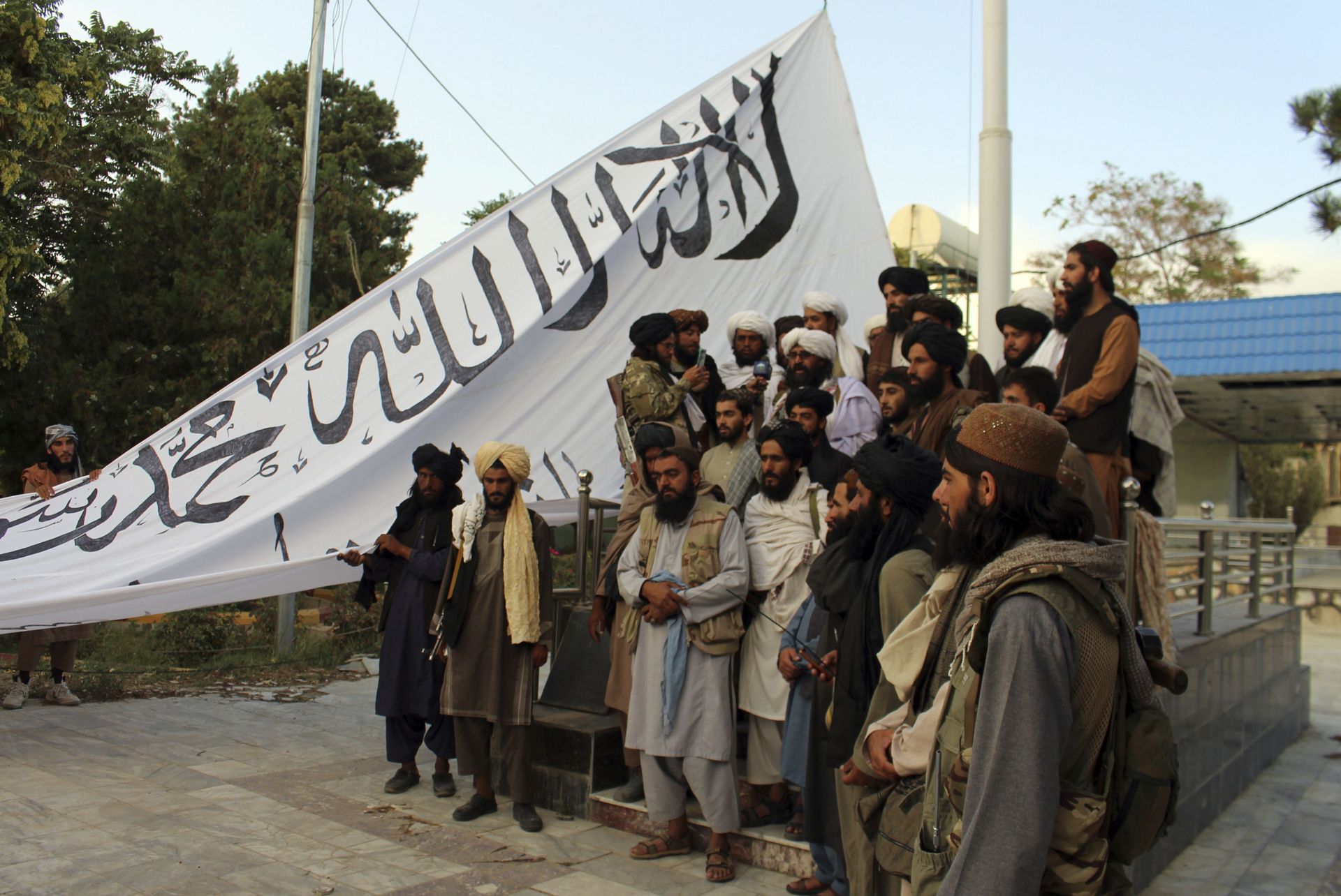 Taliban fighters poses for a photograph while raising their flag Taliban fighters raise their flag at the Ghazni provincial governor's house, in Ghazni, southeastern, Afghanistan, Sunday, Aug. 15, 2021.  - Sputnik International, 1920, 07.09.2021