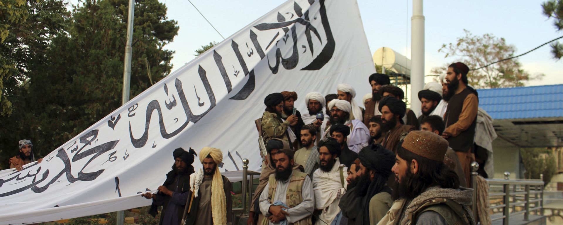 Taliban fighters poses for a photograph while raising their flag Taliban fighters raise their flag at the Ghazni provincial governor's house, in Ghazni, southeastern, Afghanistan, Sunday, Aug. 15, 2021. Taliban fighters poses for a photograph while raising their flag Taliban fighters raise their flag at the Ghazni provincial governor's house, in Ghazni, southeastern, Afghanistan, Sunday, Aug. 15, 2021. - Sputnik International, 1920, 29.08.2021