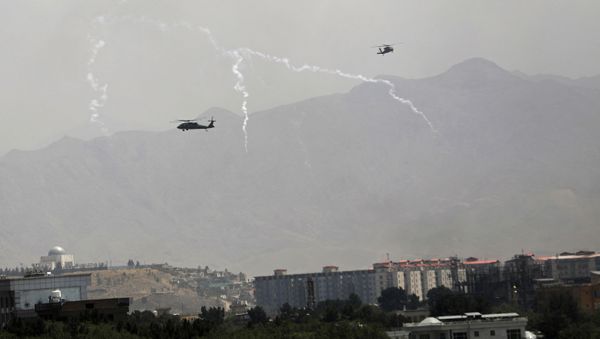 Anti-missile decoy flares are deployed as U.S. Black Hawk military helicopters and a dirigible balloon fly over the city of Kabul, Afghanistan, Sunday, Aug. 15, 2021. - Sputnik International