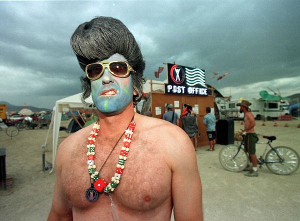 Mark, from Las Vegas, dressed as a blue-faced Elvis Presley sneers near the Burning Man Post Office at the Burning Man Festival in the Black Rock Desert of northern Nevada. Thousands of people gather at this spot each year and create a man-made city in the desert to celebrate freedom of expression and then burn The Man and other structures.   - Sputnik International