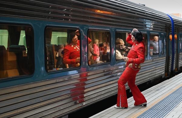 An Elvis fan uses a train window as a mirror at the Central Station before boarding a train to the Parkes Elvis Festival, in Sydney on 10 January 2019. The Parkes Elvis Festival is an annual event celebrating the music and life of Elvis Presley in the New South Wales town of Parkes. - Sputnik International