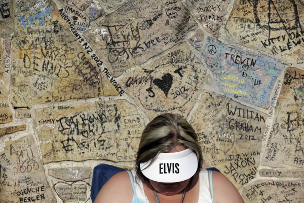 Elvis Presley fan Adrian Cornelius, of Coleman, Ala., waits in line by a graffiti-covered wall in front of Graceland, Presley's Memphis home, on Wednesday, 15 August 2012, in Memphis, Tenn. Presley fans from around the world went to Graceland to take part in the annual candlelight vigil marking the 35th anniversary of his death. - Sputnik International