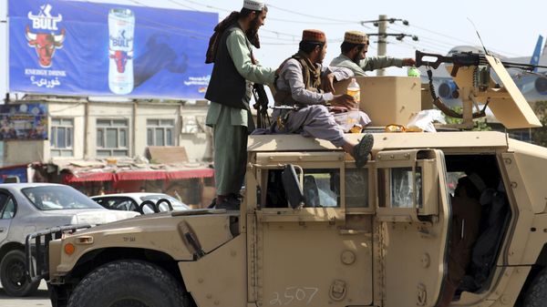 Taliban fighters stand guard in front of the Hamid Karzai International Airport, in Kabul, Afghanistan, Monday, Aug. 16, 2021. - Sputnik International