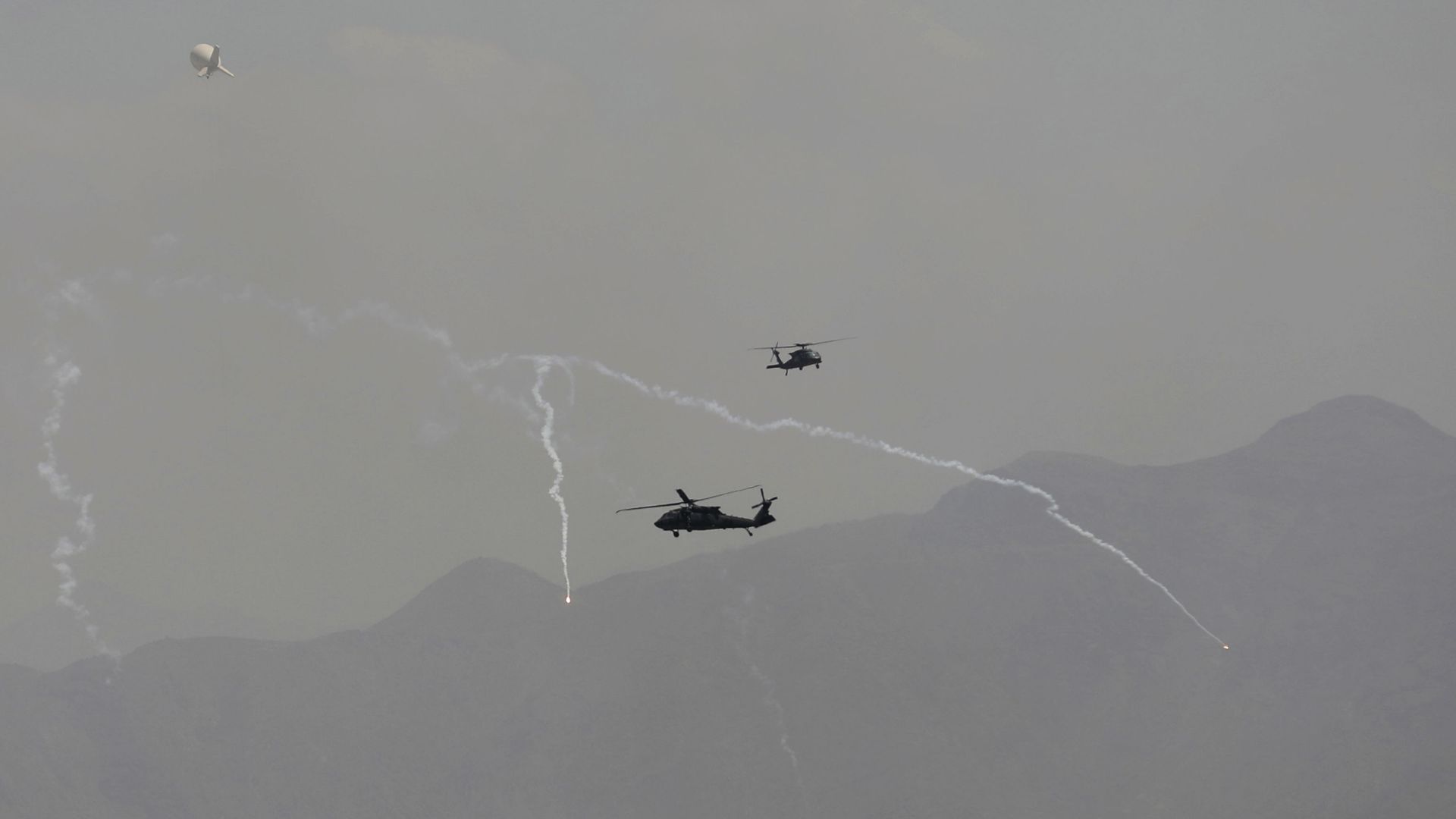 Anti-missile decoy flares are deployed as U.S. Black Hawk military helicopters and a dirigible balloon fly over the city of Kabul, Afghanistan, Sunday, Aug. 15, 2021. Anti-missile decoy flares are deployed as U.S. Black Hawk military helicopters and a dirigible balloon fly over the city of Kabul, Afghanistan, Sunday, Aug. 15, 2021. - Sputnik International, 1920, 07.10.2021