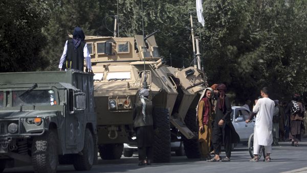 Taliban fighters stand guard on the road to the Hamid Karzai International Airport, in Kabul, Afghanistan, Monday, Aug. 16, 2021 - Sputnik International