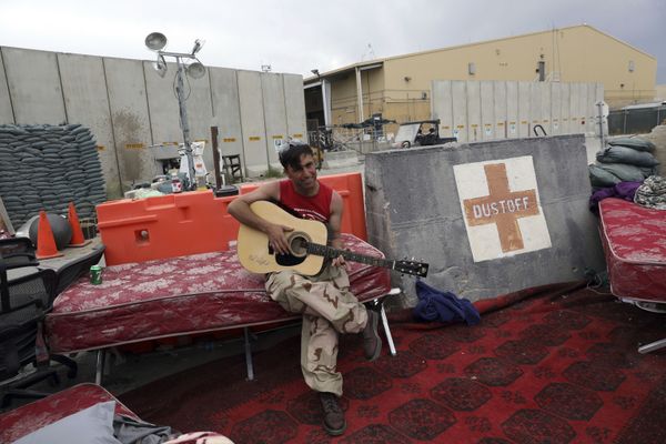 In this 5 July 2021 file photo, an Afghan soldier plays a guitar that was left behind after the American military departed Bagram air base, in Parwan province north of Kabul, Afghanistan. - Sputnik International