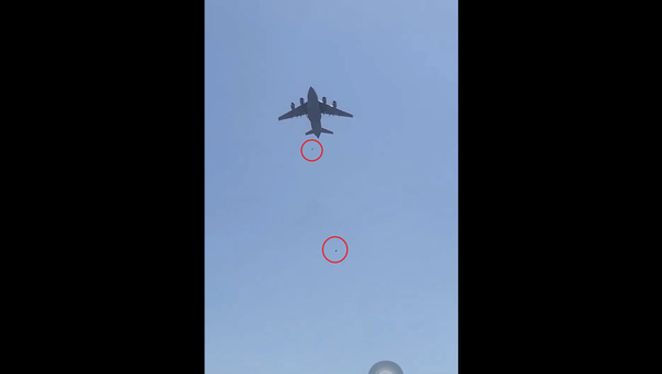 Two individuals seen falling from an American C-17 Globemaster that was evacuating Afghans and US personnel from Hamid Karzai International Airport in Kabul, Afghanistan - Sputnik International