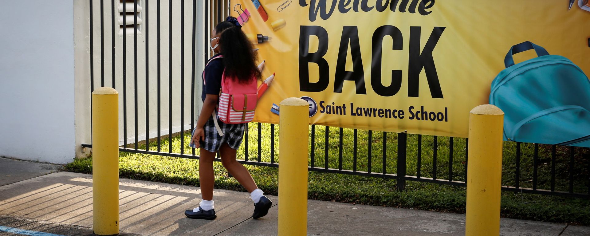 A student wearing a protective masks, walks past a “Welcome back” banner on the first day of school, amid the coronavirus disease (COVID-19) pandemic, at St. Lawrence Catholic School in North Miami Beach, Florida, U.S. August 18, 2021. A student wearing a protective masks, walks past a “Welcome back” banner on the first day of school, amid the coronavirus disease (COVID-19) pandemic, at St. Lawrence Catholic School in North Miami Beach, Florida, U.S. August 18, 2021. - Sputnik International, 1920, 29.09.2021