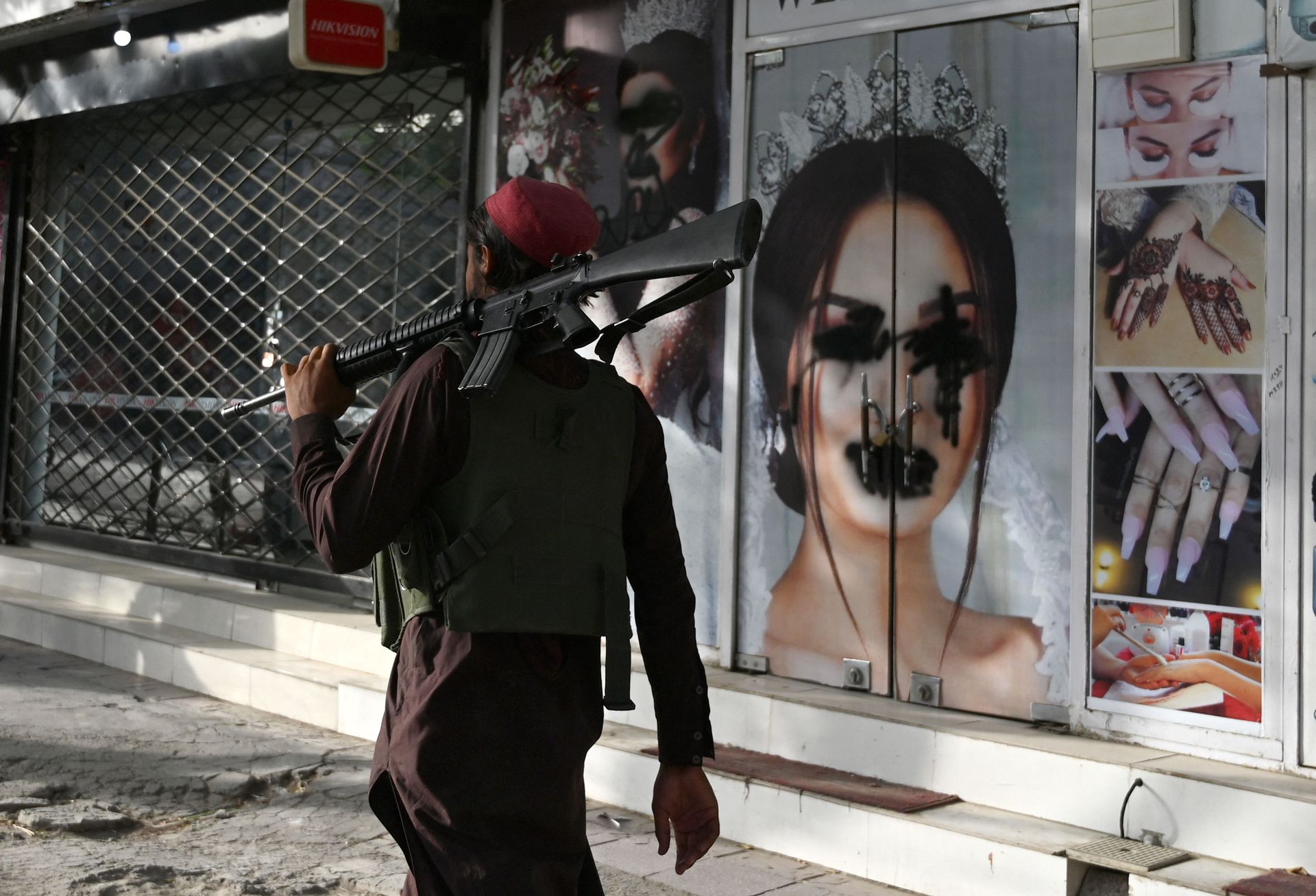 (FILES) In this file photo taken on August 18, 2021, a Taliban fighter walks past a beauty salon with images of women defaced using spray paint in Shar-e-Naw in Kabul - Sputnik International, 1920, 07.09.2021