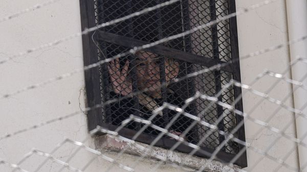 Bolivia's former interim President Jeanine Anez waves from a window of Miraflores women's jail to her supporters protesting for her release in La Paz, Bolivia, Wednesday, Aug. 18, 2021. - Sputnik International
