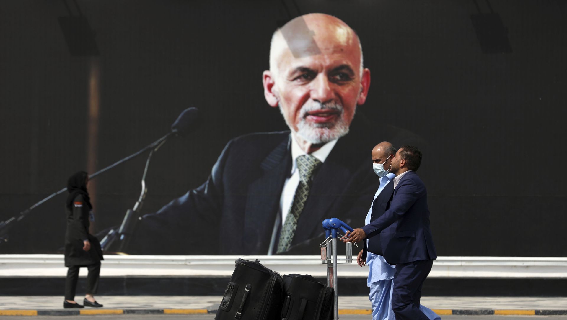 Passengers walk to the departures terminal of Hamid Karzai International Airport in Kabul, Afghanistan, on Saturday, Aug. 14, 2021, past a mural of President Ashraf Ghani, as the Taliban offensive encircled the capital. Passengers walk to the departures terminal of Hamid Karzai International Airport in Kabul, Afghanistan, on Saturday, Aug. 14, 2021, past a mural of President Ashraf Ghani, as the Taliban offensive encircled the capital. - Sputnik International, 1920, 22.08.2021