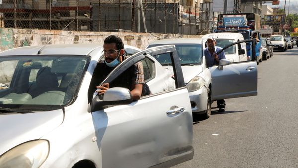 FILE PHOTO: People push their cars due to a lack of fuel, near a gas station in Dora, Lebanon, August 17, 2021. REUTERS/Mohamed Azakir/File Photo - Sputnik International