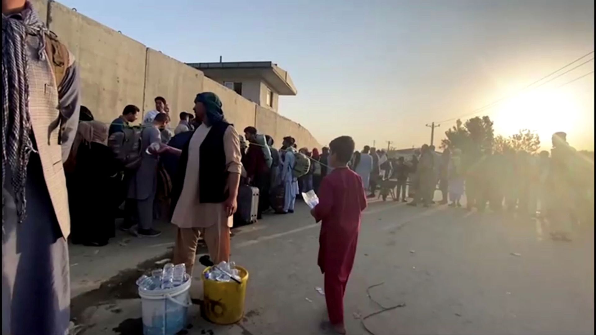A man instructs people to queue as they stand with their belongings outside Kabul airport, Afghanistan, August 22, 2021 in this still image taken from video A man instructs people to queue as they stand with their belongings outside Kabul airport, Afghanistan, August 22, 2021 in this still image taken from video - Sputnik International, 1920, 07.09.2021