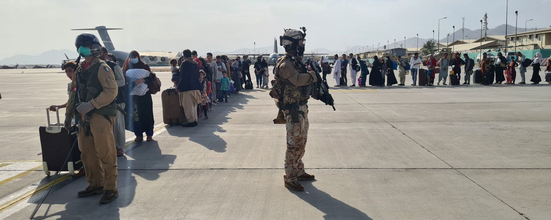 Afghan evacuees queue before boarding Italy's military aircraft C130J during evacuation at Kabul's airport, Afghanistan, August 22, 2021 Afghan evacuees queue before boarding Italy's military aircraft C130J during evacuation at Kabul's airport, Afghanistan, August 22, 2021 - Sputnik International, 1920