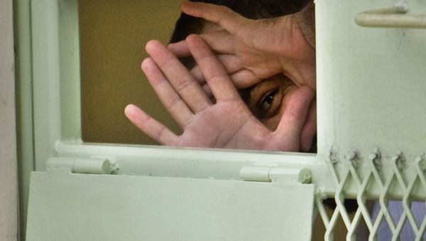 In this image reviewed by the U.S. Military, a Guantanamo detainee peers through his hands from inside his cell at the Camp Echo detention facility at the U.S. Naval Base, in Guantanamo Bay, Cuba, Tuesday, Nov. 18, 2008 - Sputnik International